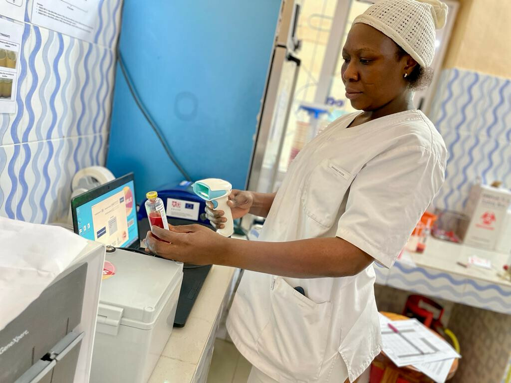 Carine Kotchare, laboratory technician at Boko hospital, scans a BactInsight blood culture bottle for measurement with the Turbi