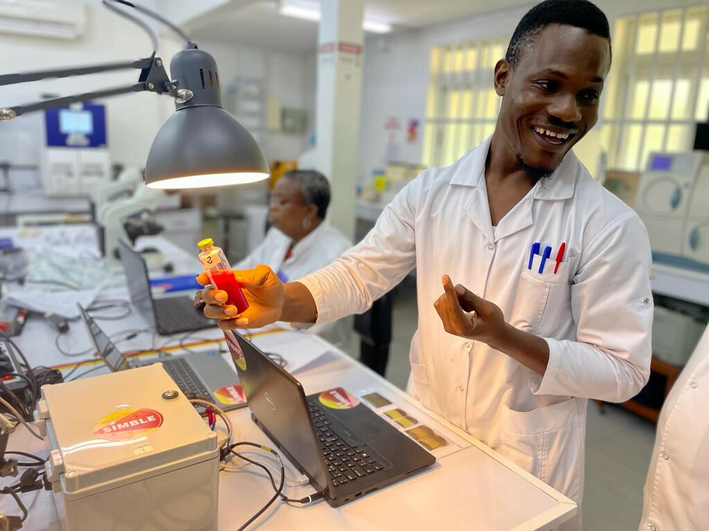 Hervé Kpoton, laboratory technician at CNHU-HKM, inspects a BactInsight blood culture bottle for signs of growth.