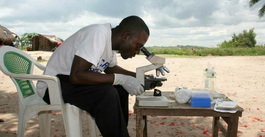 jossdinangamuzudianalysingasampleunderthemicroscopeinthevicinityofmbujimayiphotoinstituteoftropicalmedicineantwerp