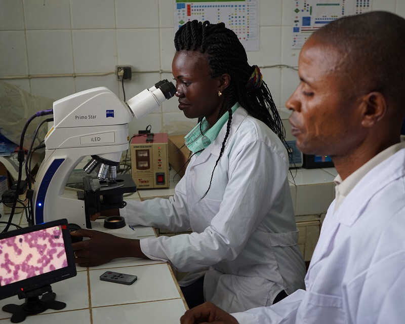 DRC-Denise-Munzadi-at-the-microscope-with-colleague-Jean-Willy-Mboma-next-to-her